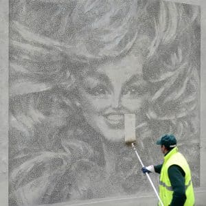 Photograph of worker, street art caricature of a woman and her hair