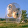 inflatable-eyeball-bubble-sculpture-field Transparent inflatable bubble containing giant eyeballs, guyed down in a grass field at dusk