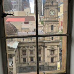 View of the Melbourne Town Hall clock tower through a window of the Manchester Unity Building