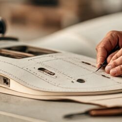 Marking a stitched panel for a mascot costume beside a sewing machine