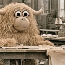 A shaggy costume mascot character on a workbench in a costume workshop